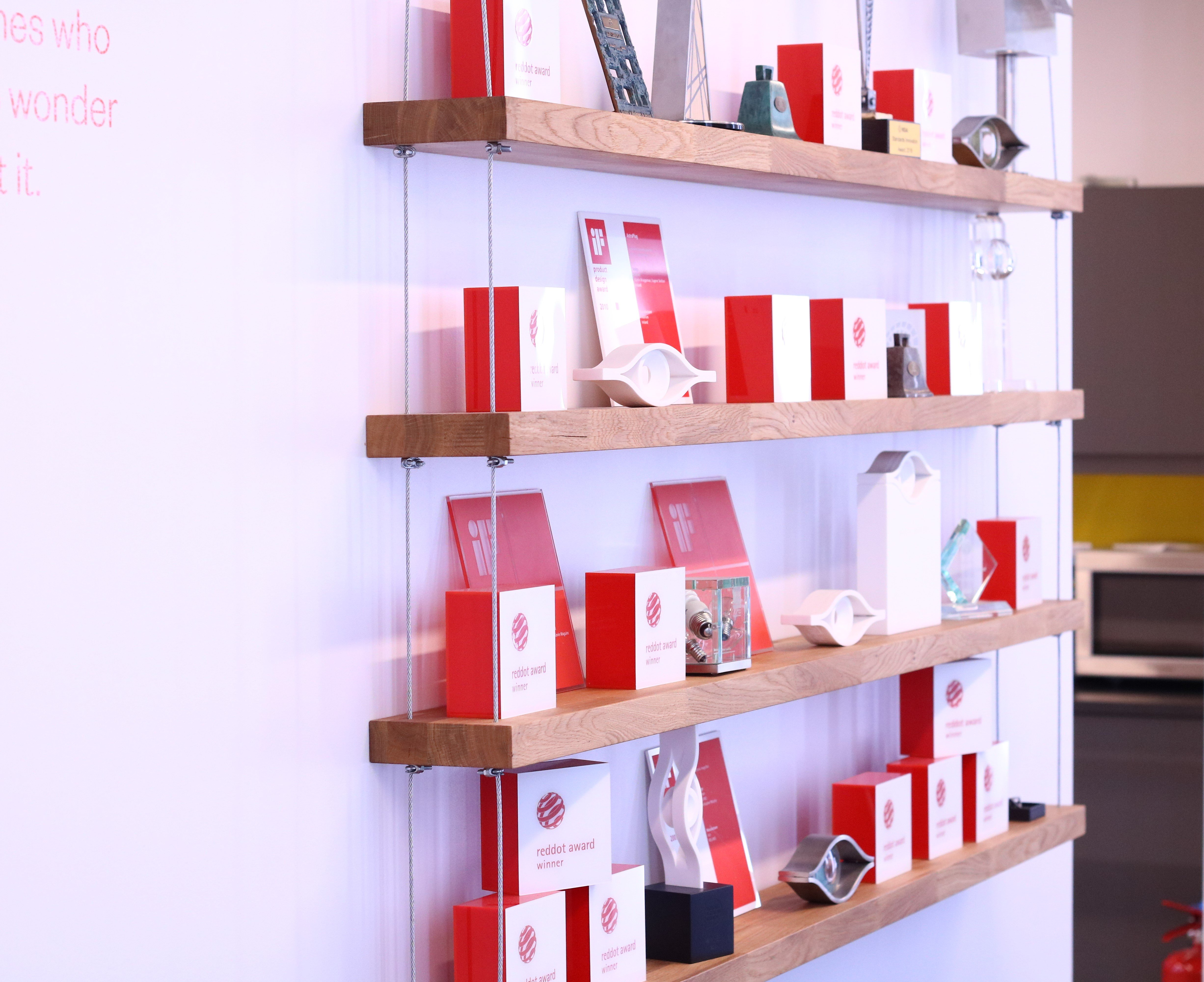 Award shelf at the Dolmen studio, there are awards from Red Dot, iF, ICAD, IDI and various other authorities on display.